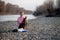 Young female volunteer collecting garbage on the river