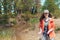 A young female volunteer collects garbage and plastic bottles near the river in a garbage bag. The concept of Earth Day and