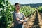 Young female winemaker in vineyard