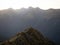 Young female woman hiking along remote alpine mountain ridge path, Brewster Hut Haast Valley, Southern Alps New Zealand