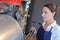 Young female worker near tank on beer brewery factory