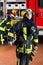 Young fireman in uniform in front of firetruck