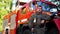 Young fireman in uniform taking off oxygen mask stands near a fire truck. Portrait of male firefighter looking into