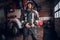 Young fireman wearing protective uniform standing next to a fire engine in a garage of a fire department