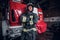 Young fireman wearing protective uniform standing next to a fire engine in a garage of a fire department