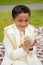 Young First Communion boy smiling with prayer book and rosary