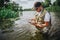 Young fisherman fishing on lake or river. Concentrated busy guy hold opened box with plastic lures for fishing. Man