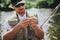 Young fisherman fishing on lake or river. Picture of process using some lure for fishing line before putting it into