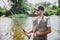 Young fisherman fishing on lake or river. Picture of serious professional guy holding rod in hands and waiting for fish