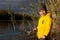 Young fisherman. preschooler boy, dressed in yellow jacket, is fishing. Portrait of smiling and happy child against background of