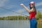 Young fisherwoman preparing for fishing. Girl with fishing rod looks at lure