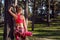 Young fit athletic woman wearing smart watch and holding yoga mat, ready for her workout in a forest. Mind and body happiness