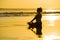 Young fit and attractive sport woman in beach sunset yoga practice workout sitting on wet sun in front of the sea in meditation an