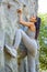 Young fit beautiful girl climbing outdoor on a artificial rock