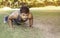 Young fit Caucasian man doing push-ups outdoors on sunny summer day. Fitness and sport lifestyle concept.