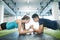 Young fit couple in gym in plank position exercising core muscle