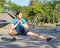 Young fit european man in activewear stretching legs while warming up outdoors