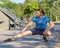 Young fit european man in activewear stretching legs while warming up outdoors