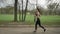 Young fit girl is running with earphones in park in summer, healthy lifestyle, sport conception, side view