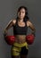 Young fit and healthy Asian Chinese woman with sweaty athletic body in fitness top and boxing gloves posing cool on isolated backg