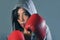 Young fit and healthy Asian Korean boxer woman in fitness top hoodie and boxing gloves posing cool badass attitude angry and defia