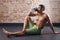 Young fit man drinking water. exercising in a gym on old red bricks background