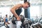 Young fit men in gym exercising with dumbbells.