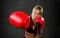 Young fit and strong attractive boxer girl with red boxing gloves fighting throwing aggressive punch training workout in gym