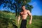 Young fit topless bodybuilder outdoors demonstrating muscles