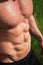 Young fit topless bodybuilder outdoors with six pack abs