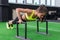 Young fit woman doing horizontal push-ups with bars in gym.