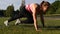 Young Fit Woman Exercising on Green Grass in Park