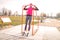 Young fit woman in fitness clothes pulls up on workout crossbar outdoors