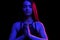 Young fit woman meditating. Neon light. Modern sci fi representation of yoga. Copy space.