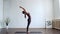 Young and fit woman practicing yoga indoor in the class. Stretching exercise in the day light. Sport, fitness, health