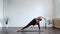 Young and fit woman practicing yoga indoor in the class. Stretching exercise in the day light. Sport, fitness, health