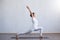 Young and fit woman practicing yoga indoor in the class. Stretching exercise in the day light. Sport, fitness, health