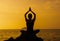 Young fit woman using yoga technique for meditation and well-being on beach at sunrise