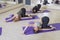 Young fit Women on a Yoga Pilates group class in gym. They stretch, stay in asana poses in sport outfit. Daylight. Indoors