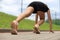 Young fitness attractive sporty girl runner in start position, closeup on shoe, outdoor