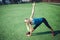 Young fitness girl doing stretching in the sunset . Football field.