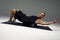 Young fitness trainer instructor sporty man sportsman on foam roll and yoga mat isolated on gray background. Workout
