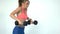 Young fitness woman doing exercise with dumbbells in the gym.