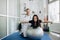 Young fitness woman doing kinesiotherapy rehabilitation exercise with personal rehabilitation specialist in the gym