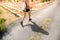 Young fitness woman hiker legs at rural trail. Shadow silhouette of the woman walking