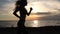 Young fitness woman jogging on seaside at sunset