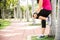 Young fitness woman runner feel pain on her knee in the park. Outdoor exercise activities concept