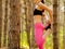 Young Fitness Woman Stretching her Legs in the Pine Forest. Female Runner Doing Stretches . Healthy Lifestyle Concept.