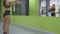 Young fitness woman training in front of the mirror at the gym. Female athlete stretching her body and hands before