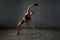 Young fitnesswoman stretching under rain.